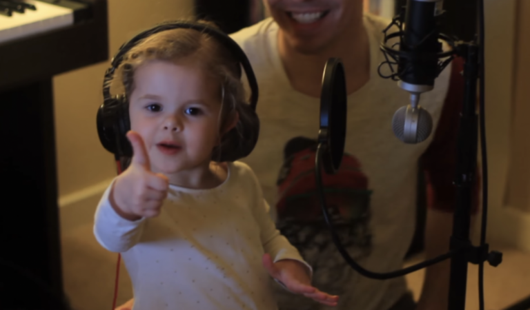 Dad asks his toddler daughter to sing. When she steps up to the mic she’ll blow you away