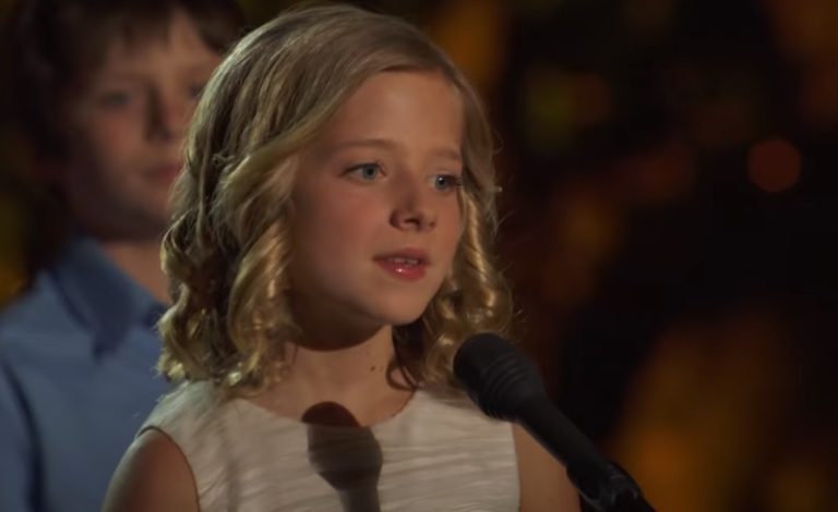 The young girl in the center begins to sing, and the audience is left speechless