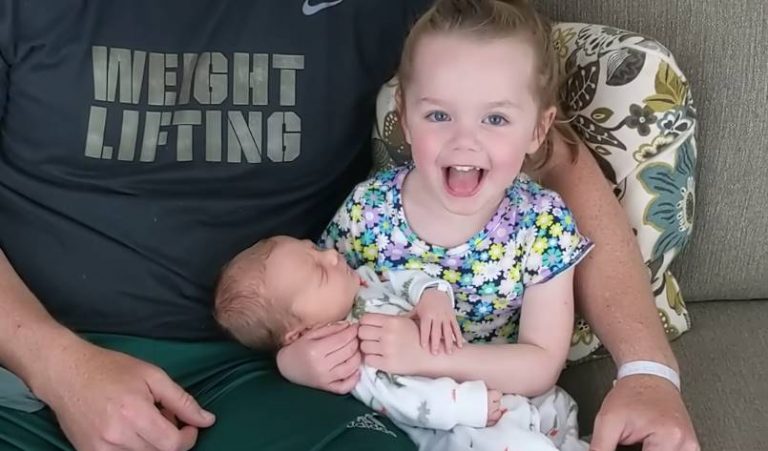 The sister meets her baby brother for the first time. Her emotions and reaction are everything