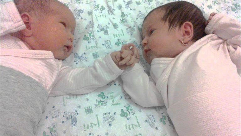 Newborn Twin Boy and Girl Hold Hands and Chat Sweetly