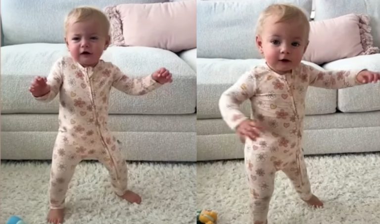 A little 1-year-old girl taking her first steps while dancing.